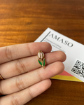 Small tulip-shaped pendant held between fingers with a 'JAMASO' card in the background.