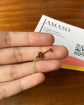 Small key-shaped object held between fingers with AMASO branding in the background