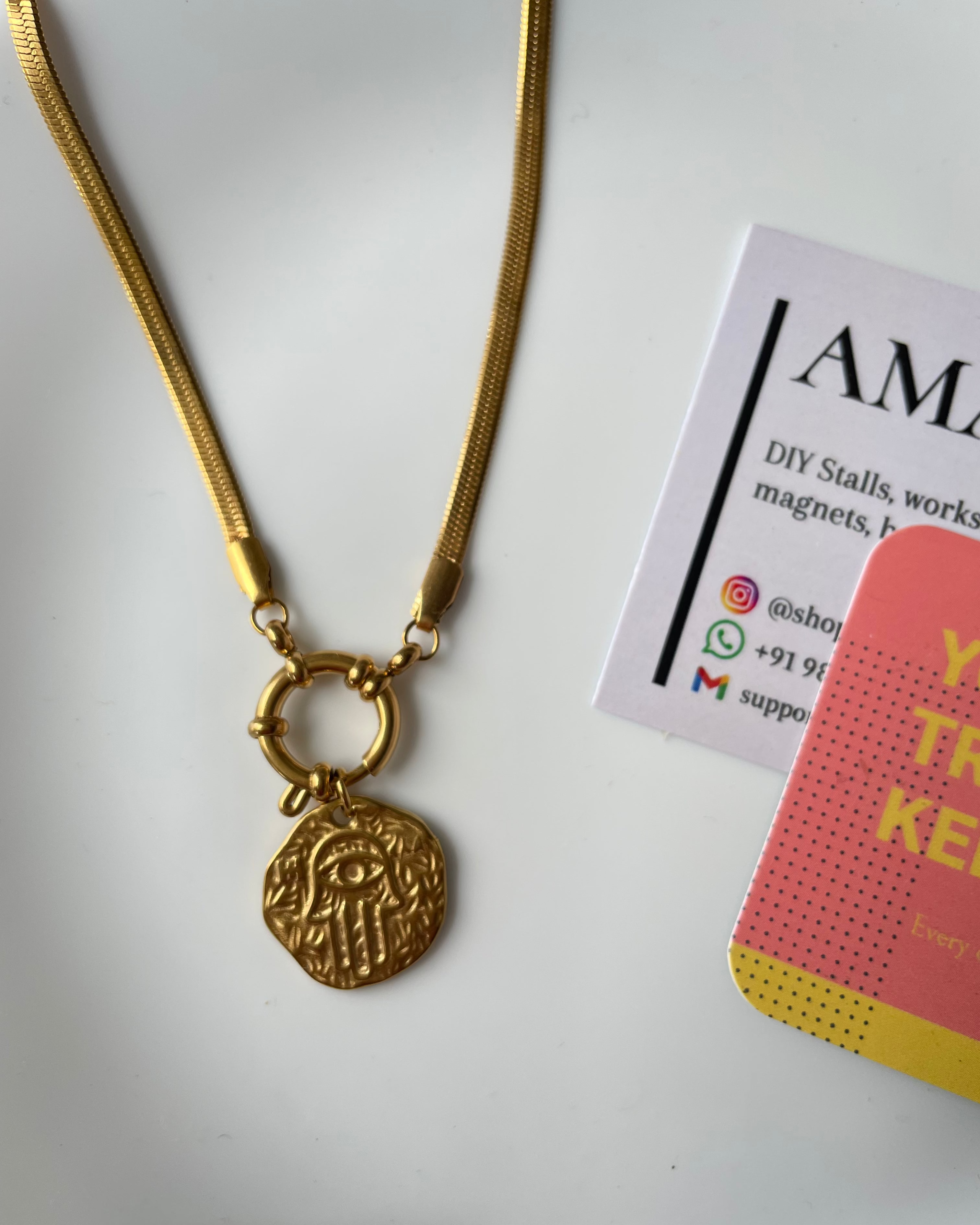 Gold necklace with a pendant on a white background