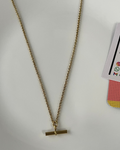 A gold chain necklace with a flat bar toggle clasp, laid out on a white surface.